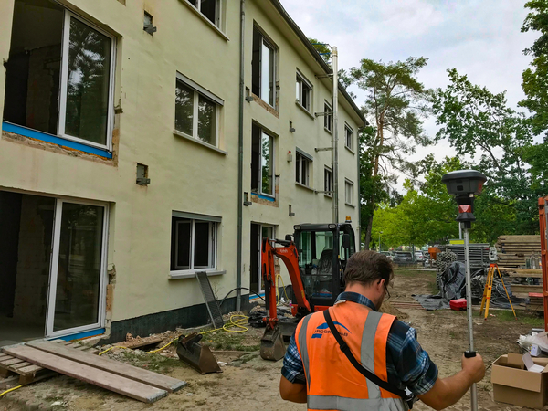 Ein Vermessungstechniker ist auf einer Baustelle im Fichte Hof in Ludwigsfelde